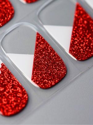 Nahaufnahme der Zipfelglitzer UV Gel Wraps – rotes Glitzerfinish mit diagonaler Weißkante und kleinen Mützenakzenten.
