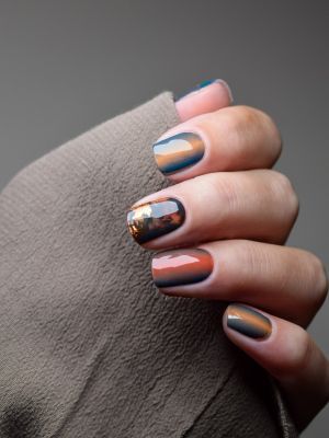 Hand mit Nailpolish Wraps Nevio Harvest Fall – warmes Ombre in Braun-Orange mit goldenen Herbstblättern.