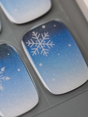 Nahaufnahme der Flockentanz UV Gel Wraps – klare Blautöne mit feinen Schneeflocken-Motiven für einen kühlen, edlen Look