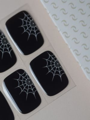 UV Gel Wraps Spooky Days – schwarzer Hintergrund mit weißen Spinnennetzen, auf Bogen in Nahaufnahme.
