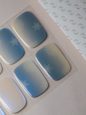 Eiskristall UV Gel Wraps – hellblau-weißes Schneeflocken-Design mit glitzerndem Finish auf den Nägeln.