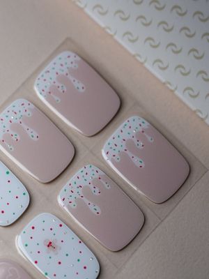 Holiday Treats UV Gel Wraps – festliches Design mit Zuckerstangen, Lebkuchen und bunten Streuseln auf Nude-Basis.