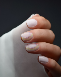 Hand mit UV Gel Wraps Puderschimmer – Nude-Rosa mit irisierenden Glitzerlinien.