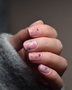 Gingerbread Lights UV Gel Wraps – rosa Nageldesign mit bunten Lichterketten und kleinen Lebkuchenmännchen.